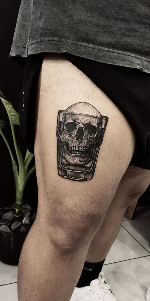 Skull in whiskey glass blackwork thigh piece